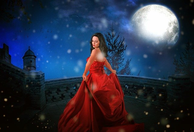 Dívka ve večerní krajině v červených dlouhých šatech